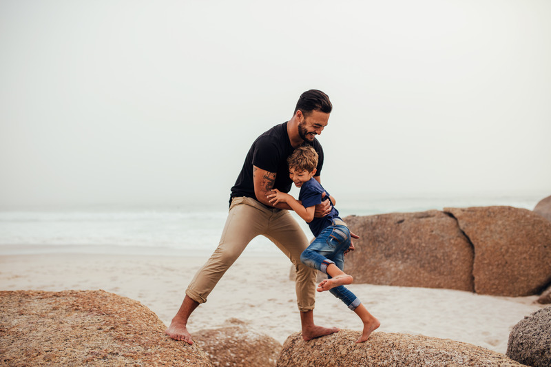 Un pere joue avec son fil à la plage